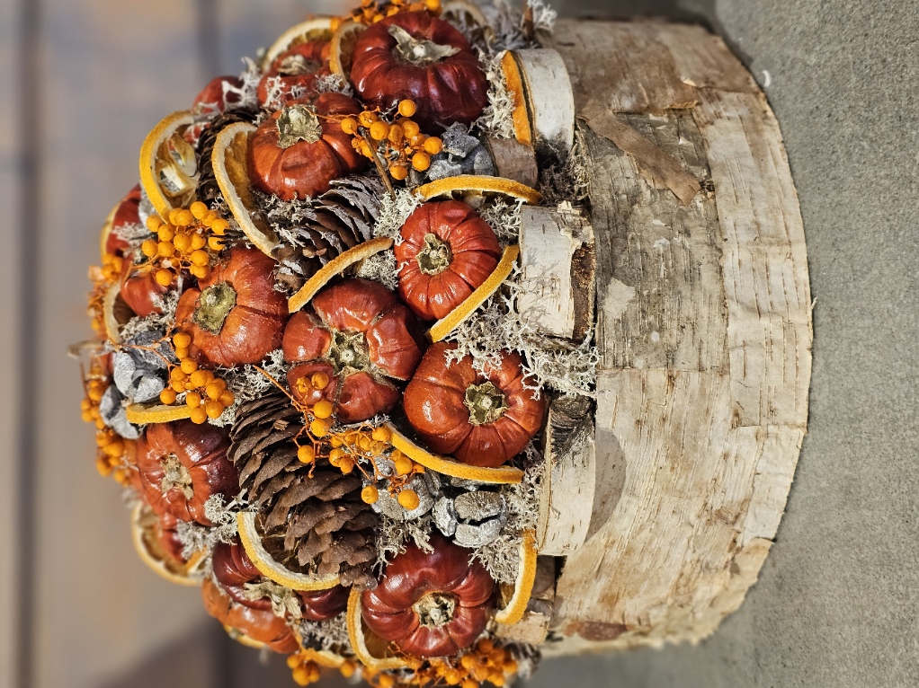 Pompoentaart met droogbloemen, dennenappels en sinaasappel